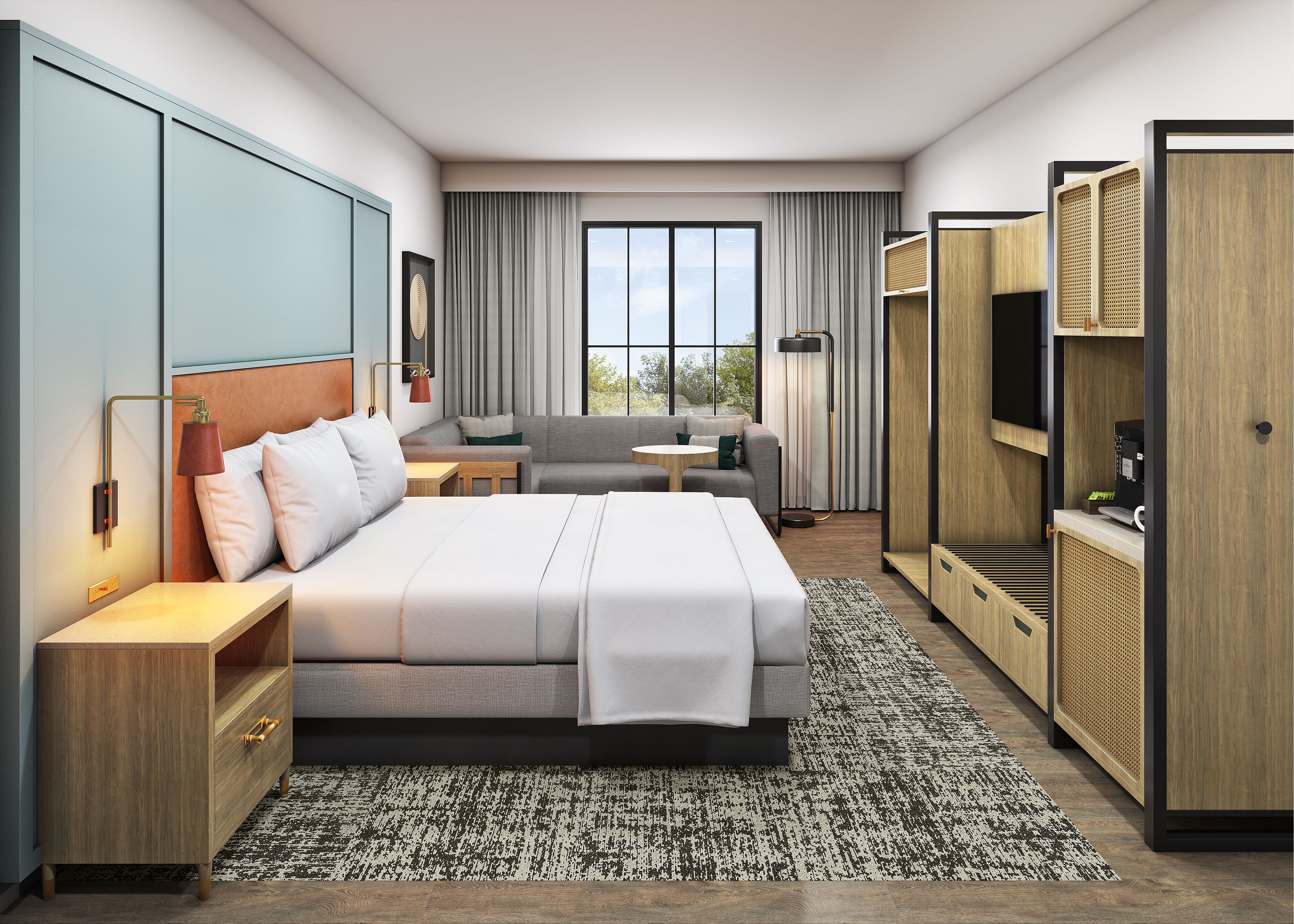 A modern hotel room with a large bed, a sofa, a desk, and a TV.