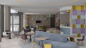 A modern interior with a central seating area, a bar, and a TV screen. - Hampton By Hilton Eskisehir (Eskisehir)