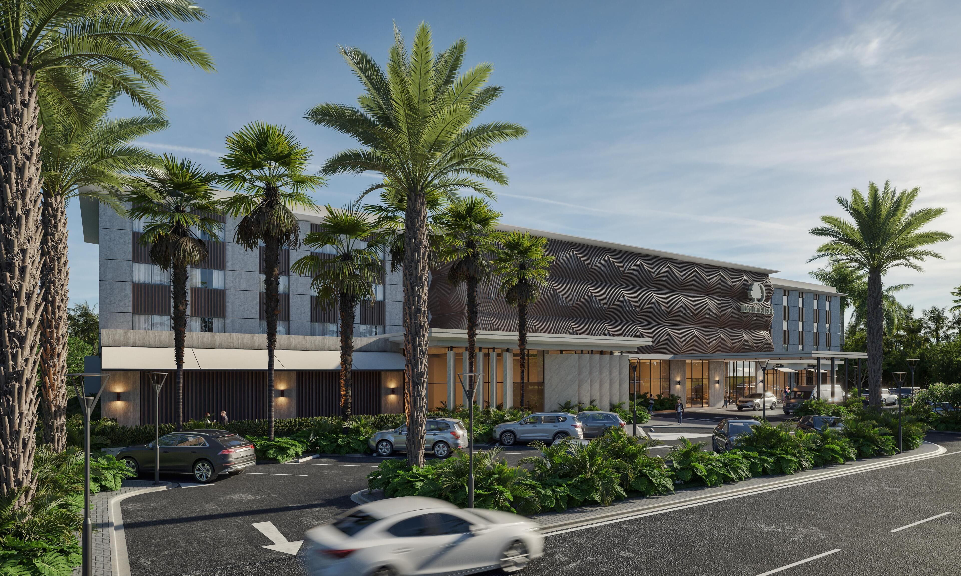 A modern hotel with a geometric facade, palm trees, and a parking area.