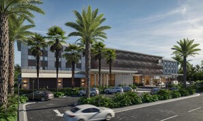 A modern hotel with a geometric facade, palm trees, and a parking area. - Doubletree By Hilton Punta Cana Downtown (Punta Cana)