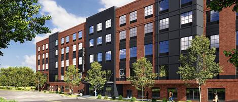 A modern multi-story building with a mix of brick and glass facades, featuring a prominent 'HOME SUITES' sign.