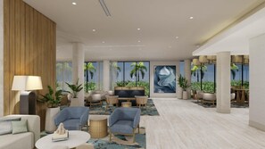 A modern hotel lobby with a seating area, a television, and a large window with a view of palm trees.