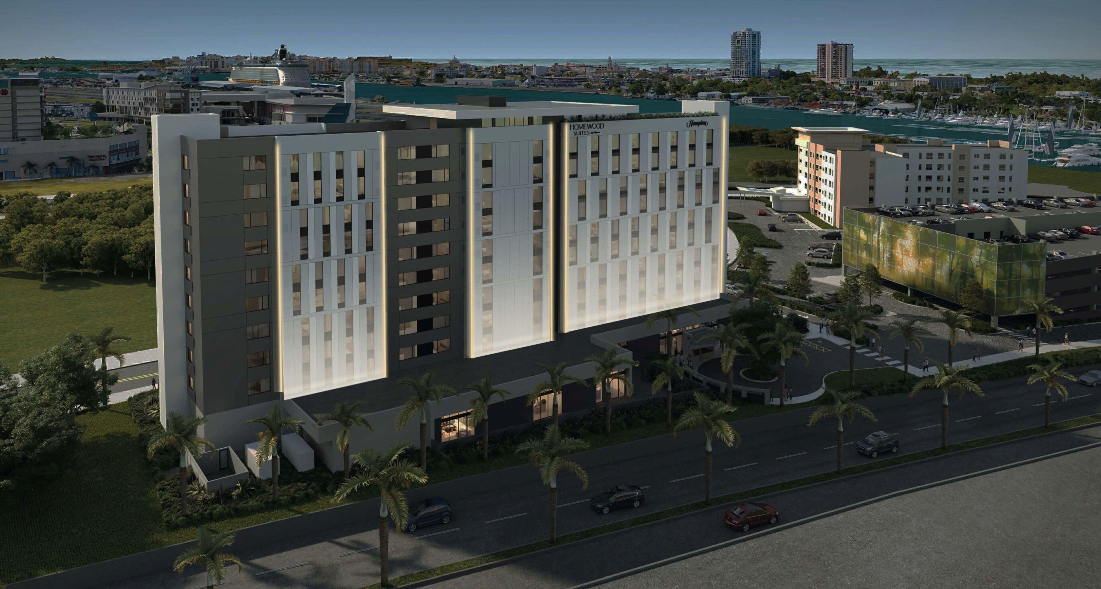 Un hotel moderno con un patio central, rodeado de palmeras y un puerto deportivo al fondo.
