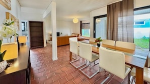 A modern dining area with a brick floor, white furniture, and a chandelier. - Frankfurt east Family House (Heusenstamm)