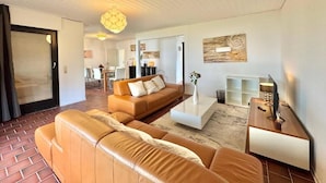 A modern living room with a sectional sofa, a coffee table, and a television. - Frankfurt east Family House (Heusenstamm)