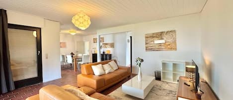 Una sala moderna con un sofá modular, una mesa de centro y un televisor.