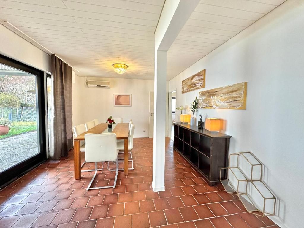A modern interior with a dining area, a hallway, and artwork on the walls.