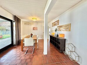 A modern interior with a dining area, a hallway, and artwork on the walls.