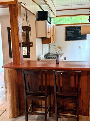 Una cucina con mobili in legno, un piano cottura a gas e un lampadario.
