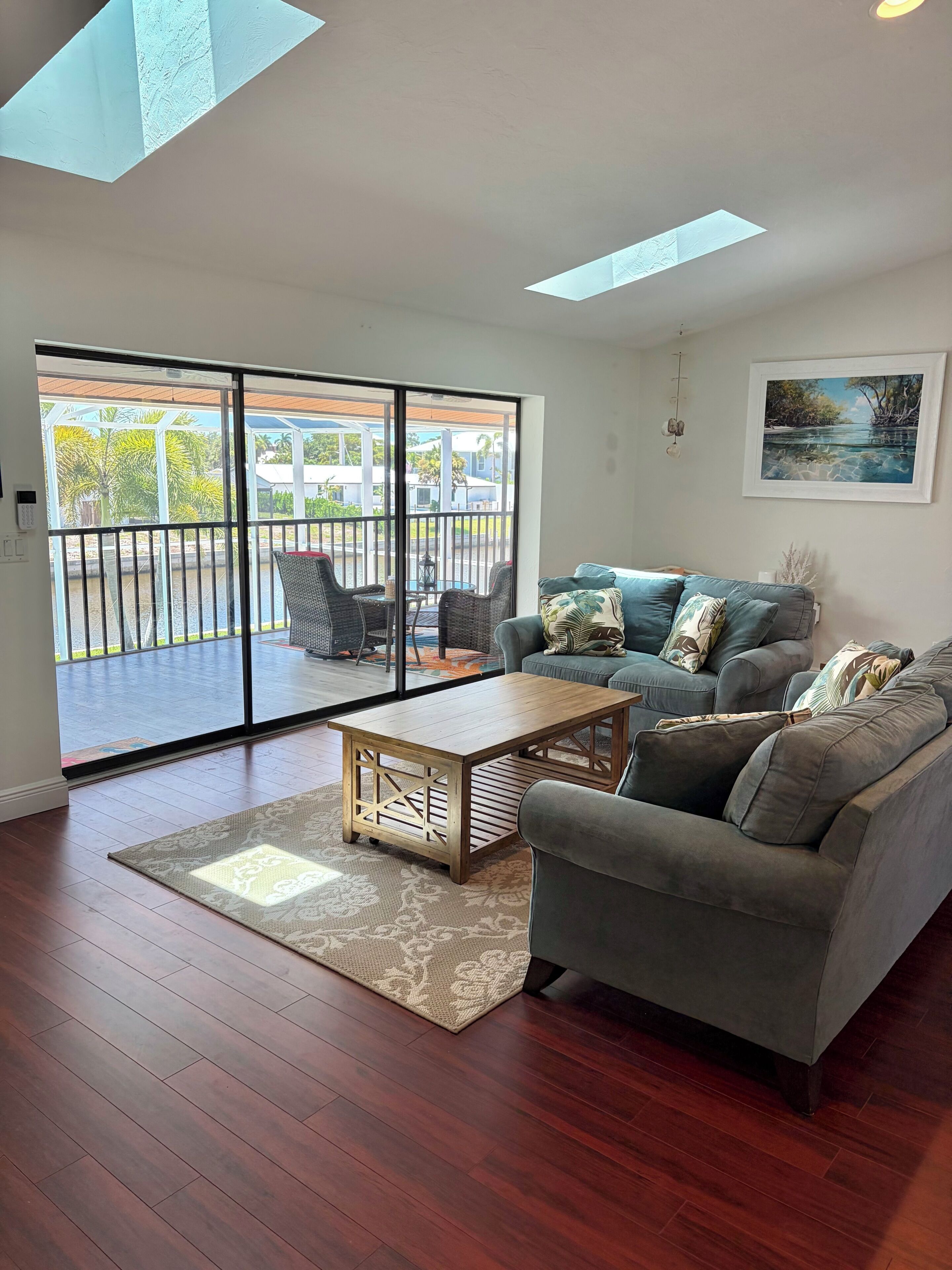 A living room with a grey sofa, a wooden coffee table, and a patterned rug.