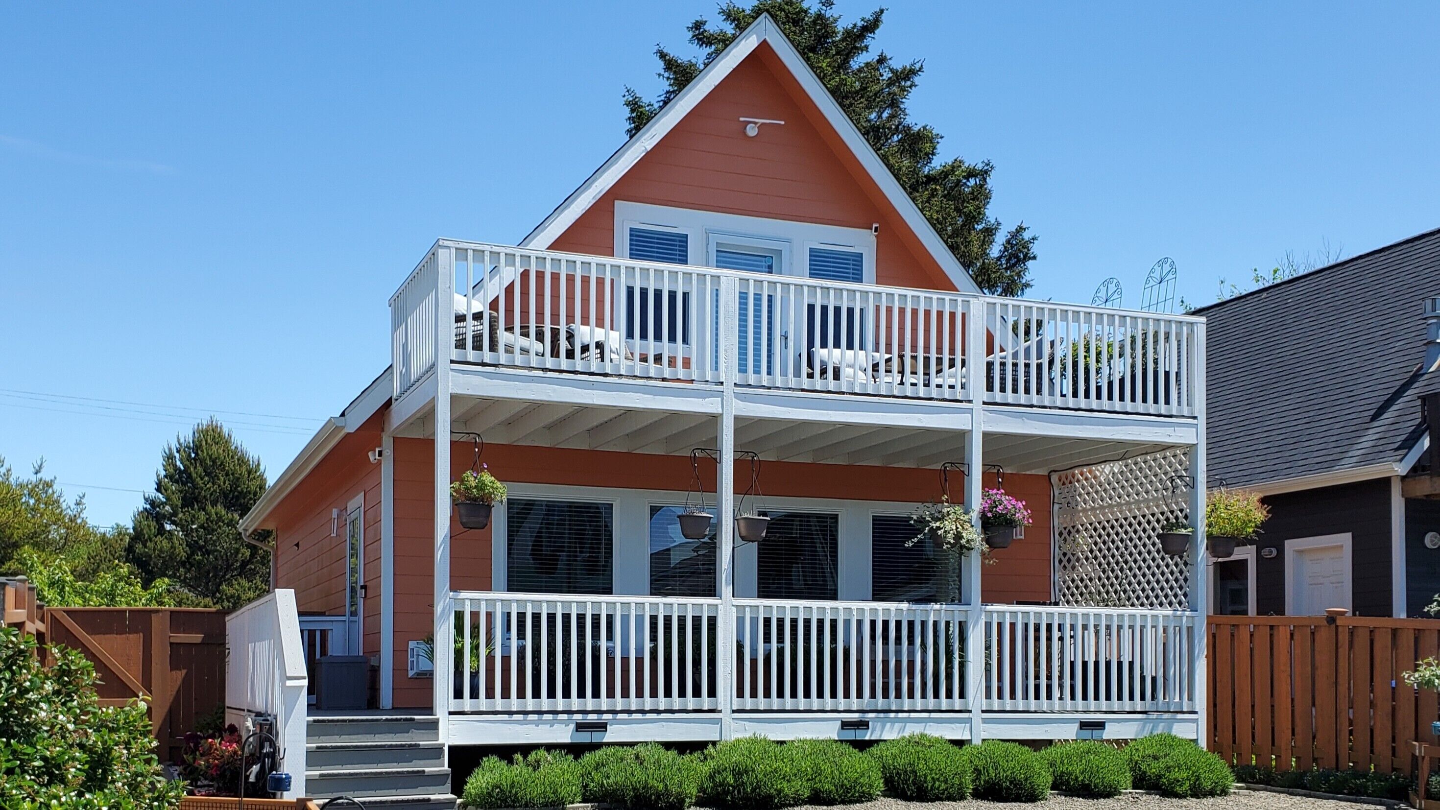A two-story house with a balcony, a front porch, and a fenced yard.