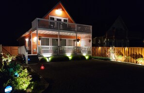 A two-story house with a balcony and a fenced yard at night. - Sunkissed 3BR - Oceanview Pacific Beach Home (Pacific Beach)