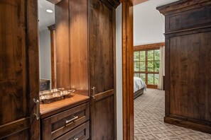 A bedroom with a large wooden wardrobe, a dresser, and a bed. - Luxury 2BR St. Regis Aspen Condo with Concierge & Housekeeping (Aspen)