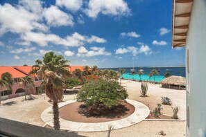 Ein Resort mit Poolbereich, Palmen und Blick auf den Ozean.