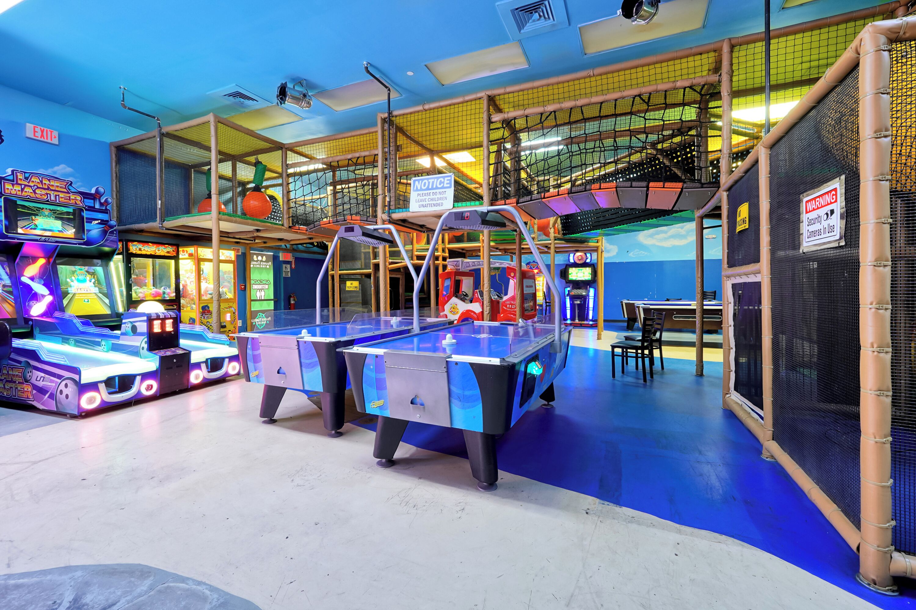 An indoor play area with various arcade games, a foosball table, and a pool table.