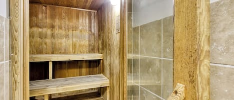 Eine Holzsauna mit einer Bank und einem gefliesten Boden.