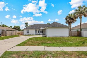 A single-story residential house with a front garage, a well-maintained lawn, and a clear sky. - Pool Retreat | Near USSSA | Beach & Launches (Rockledge)