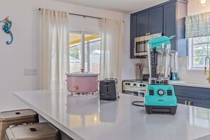 A kitchen with a modern blender, a pink slow cooker, and a toaster on the counter. - Pool Retreat | Near USSSA | Beach & Launches (Rockledge)
