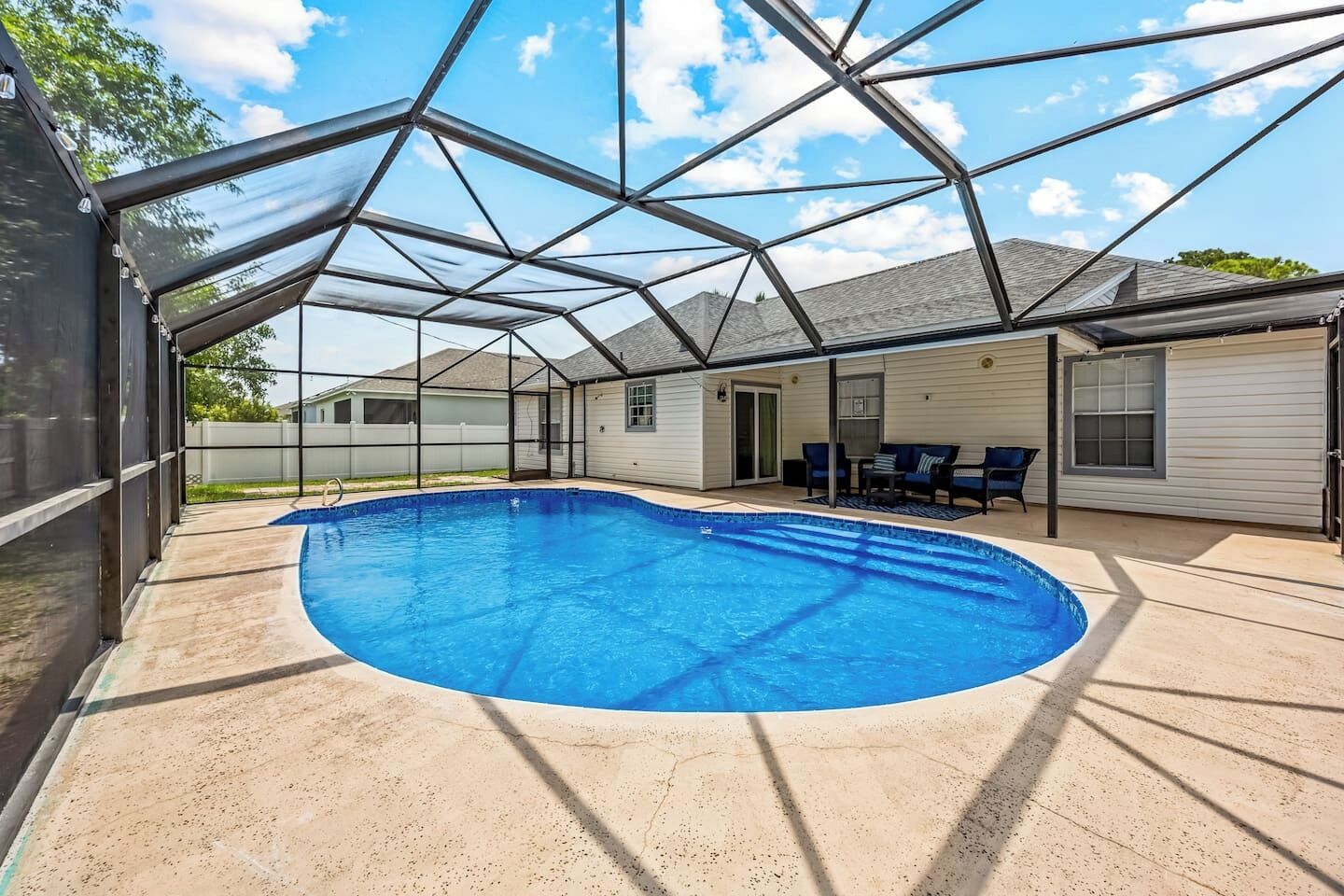 A covered outdoor swimming pool with a clear roof structure.