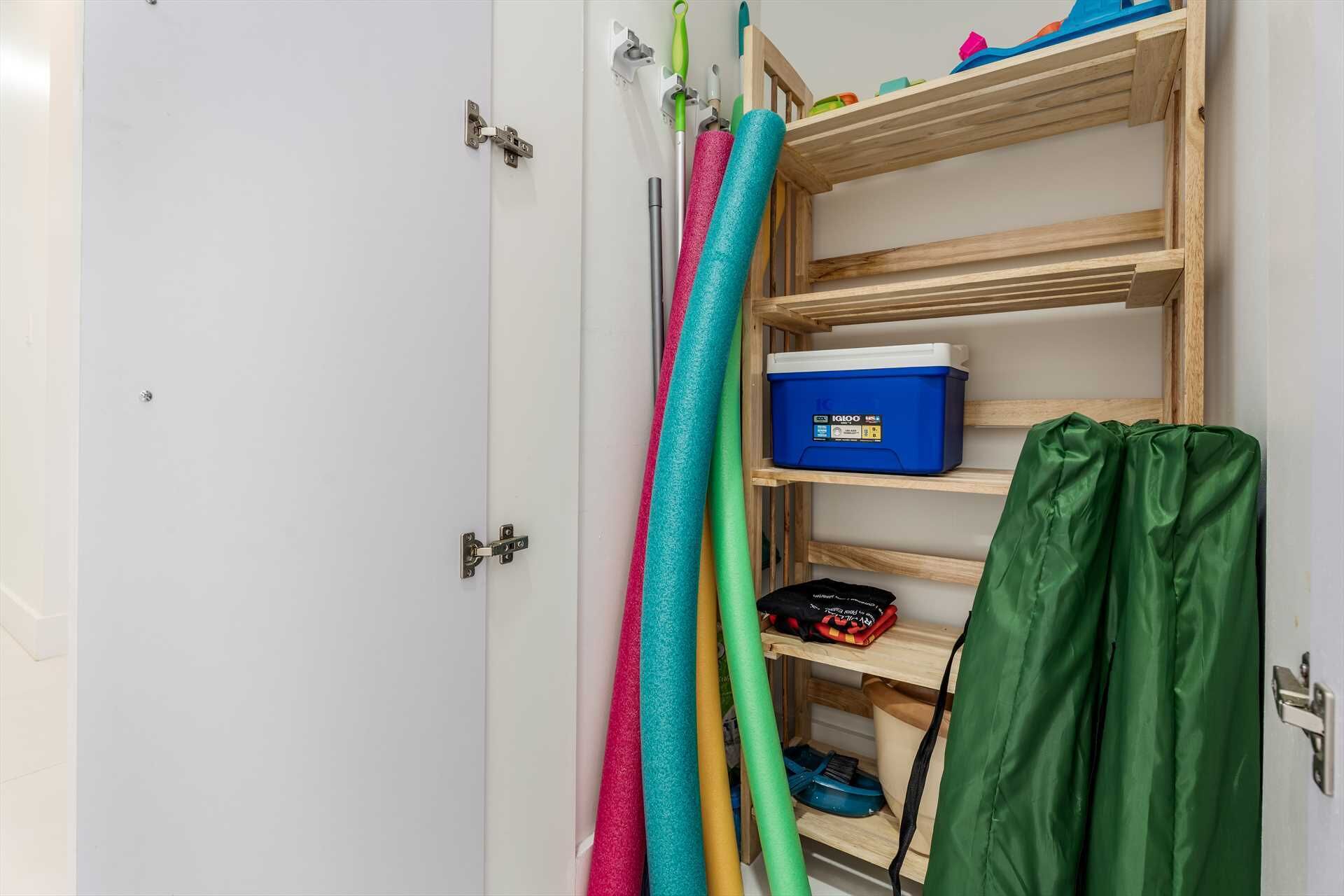 Ein Zimmer mit einer weißen Tür, einem hölzernen Regal mit einer blauen Aufbewahrungsbox und bunten Matten.