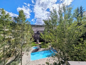 Une propriété résidentielle dotée d’une piscine, d’un patio et offrant une vue sur une chaîne de montagnes.