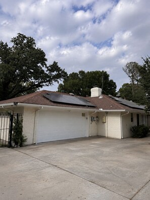 A single-story house with a garage, a chimney, and a solar panel on the roof. - Rustic TX Escape in DFW, Near Stadium, Airport & Downtown (Fort Worth)