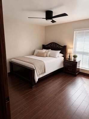 A bedroom with a bed, a nightstand, a lamp, and a ceiling fan. - Spacious Getaway : 4BR-10Guest House Near AT&T Stadium, DFW Airport & Stockyards (Fort Worth)