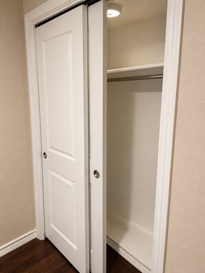 A closed white door with a silver handle, leading to a closet with a metal rod shelf. - Spacious Getaway : 4BR-10Guest House Near AT&T Stadium, DFW Airport & Stockyards (Fort Worth)