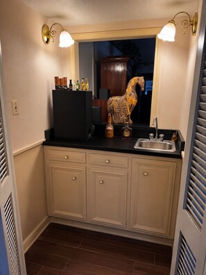 A kitchen with a black countertop, a sink, and a decorative horse statue. - Spacious Getaway : 4BR-10Guest House Near AT&T Stadium, DFW Airport & Stockyards (Fort Worth)