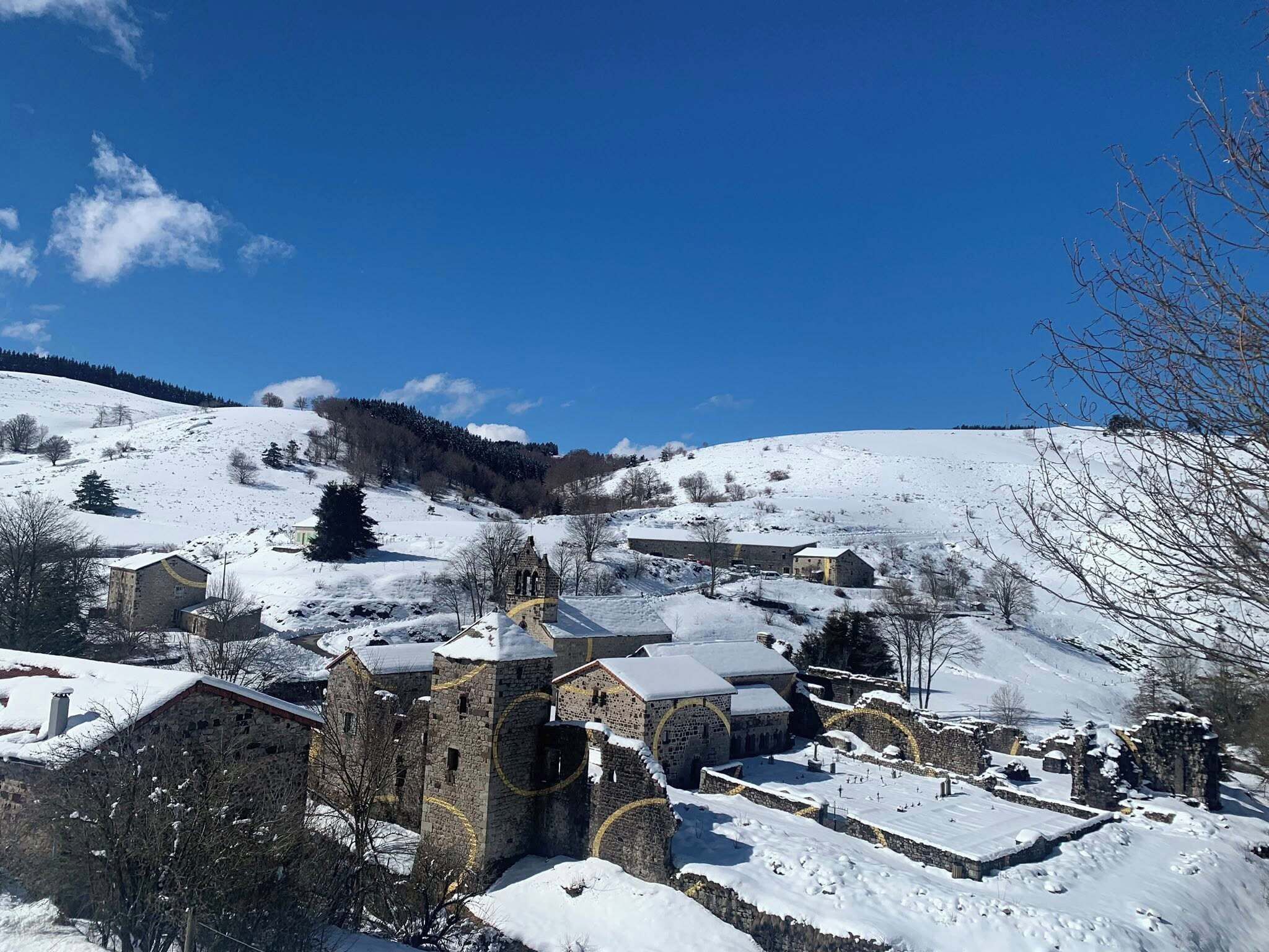 A snow-covered village with stone buildings and a church.