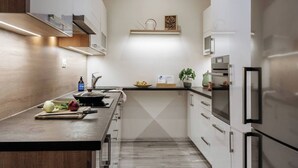 Una cocina moderna con una encimera larga, electrodomésticos de acero inoxidable y un salpicadero de madera.