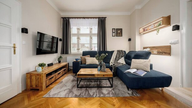 Una sala de estar con sofá, mesa de centro, televisor y un mueble de madera.