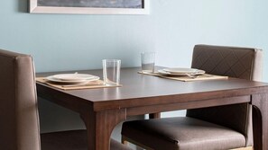 Une table à manger avec deux assiettes, deux verres et un carnet.