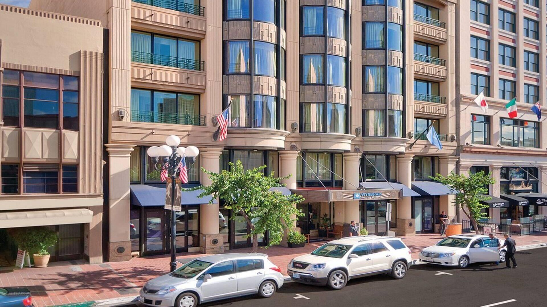 A multi-story hotel with a classic architectural style, featuring large windows and a central entrance with a flag.