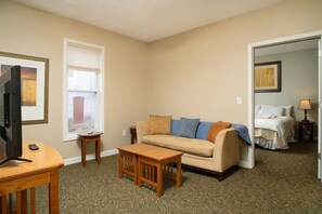 A hotel room with a sofa, a television, a small table, and a bed. - 315 Cozy 2BR – free parking Medium & Long term (Indianapolis)