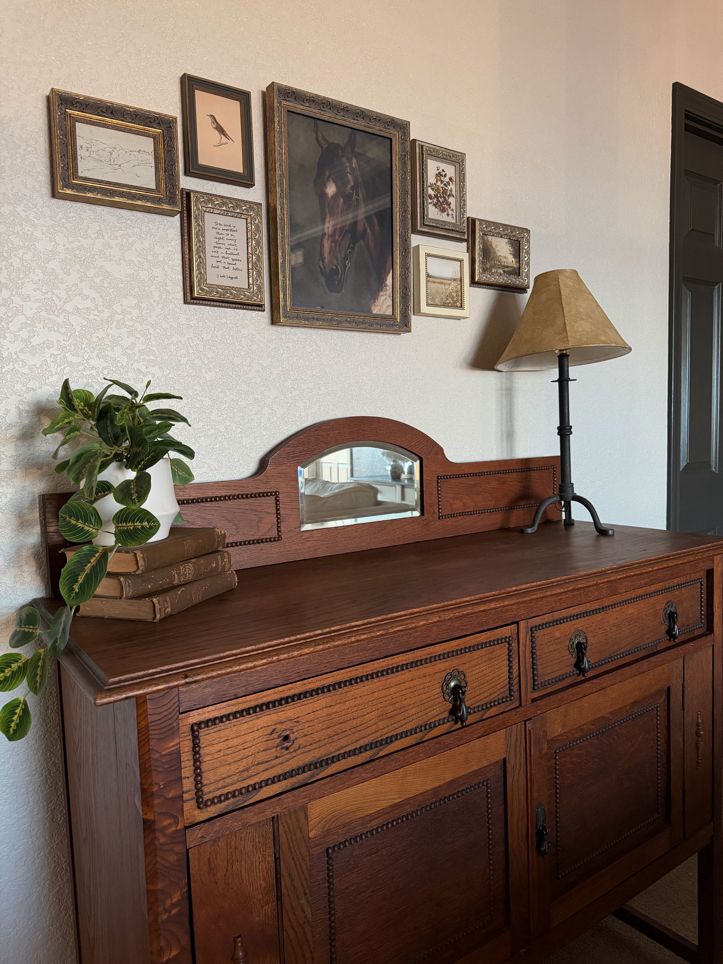 A wooden dresser with drawers, a mirror, and a lamp.