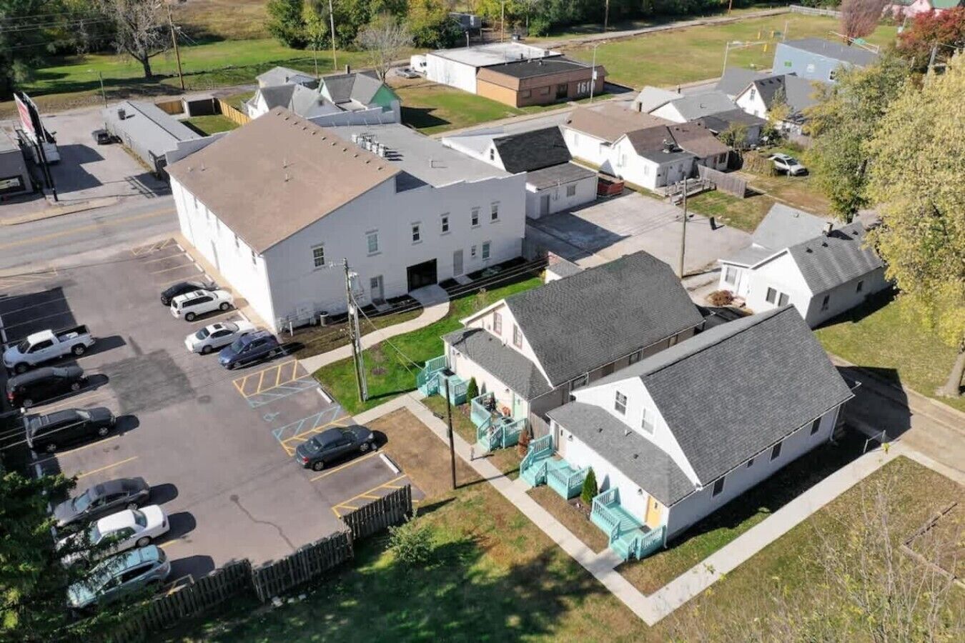 Un quartier résidentiel comprenant plusieurs maisons, un parking et un petit espace vert.