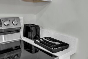 Eine Küche mit Herd, Toaster und einem Tablett mit Geschirr.
