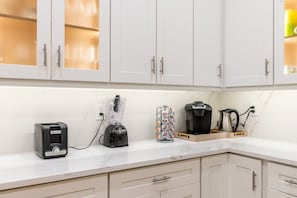 A kitchen with white cabinets, a toaster, a Keurig coffee maker, and a coffee grinder on the counter. - Spacious Waterfront  house in fabulous Fort Lauderdale on Las Olas! (Fort Lauderdale)