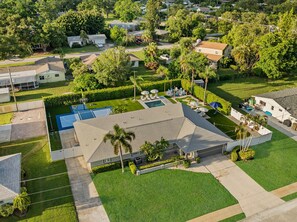 A residential property with a swimming pool, a tennis court, and a covered patio area. - Elegant 5BR Retreat- Pickleball + Mini golf + Pool (Bradenton)
