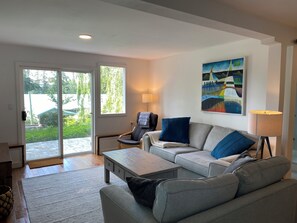 A modern living room with a sofa, coffee table, and a painting on the wall.