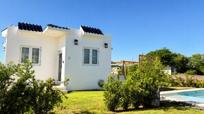 A two-story white building with a tiled roof, a swimming pool, and a well-maintained lawn. - Beach Lote Villas - Villa 2 +Pool- Islote (Arecibo)
