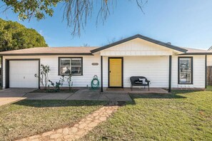 Une maison de plain-pied avec un garage, une porte d’entrée et un petit porche.