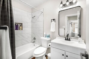Une salle de bain moderne équipée d’une baignoire, de toilettes et d’un lavabo.