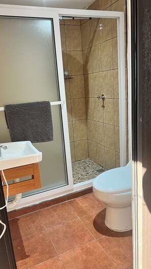 A bathroom with a shower, toilet, and sink. - Hotel El Tambor OASIS Antigua Guatemala (Antigua Guatemala)