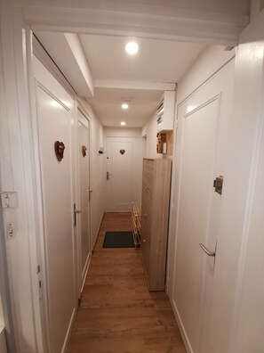 A narrow hallway with white doors, wooden flooring, and a central light fixture. - Perfect for families, with a view of the slopes, in the heart of the resort (Besse-et-Saint-Anastaise)