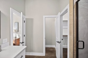 A hallway with white walls and doors leading to a closet with a marble floor. - Brand New Home: Perfect for Long Stays (Buffalo Gap)