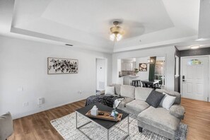 Un salon moderne avec un canapé, une table basse et un coin repas à l’arrière-plan.