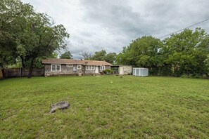 A residential property with a detached house, a fenced yard, and a small shed. - Modern Comfort 4BR House w/ Large Yard (Abilene)