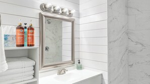 A bathroom with a white vanity, a mirror, and a bathtub. - Modern 2BR Home with Pool Table & Yard (Abilene)